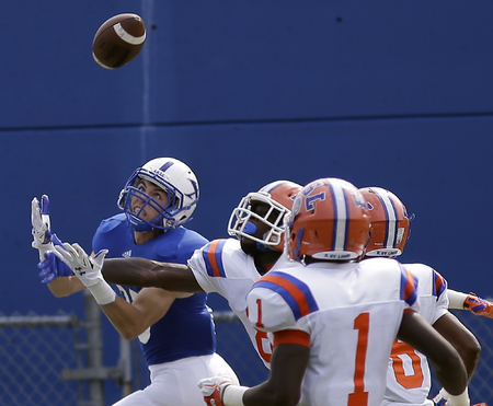 St. Xavier's Brian Johnston tries to catch a pass in front of East St. Louis defenders, during their football game