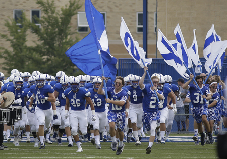 St. Xavier bombers run on the field before their football game against East St. Louis
