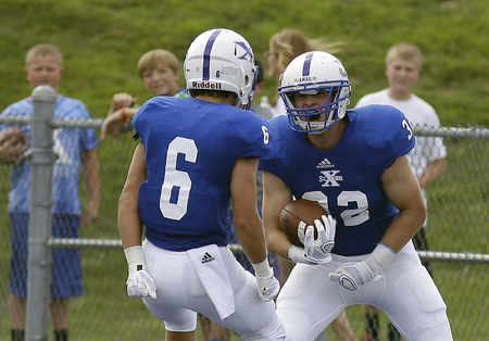 St. Xavier's Sean Prophit (32) celebrates with teamate Sam	 Ankenbauer after scoring a touchdown during the Bombers football game against East St. Louis, 